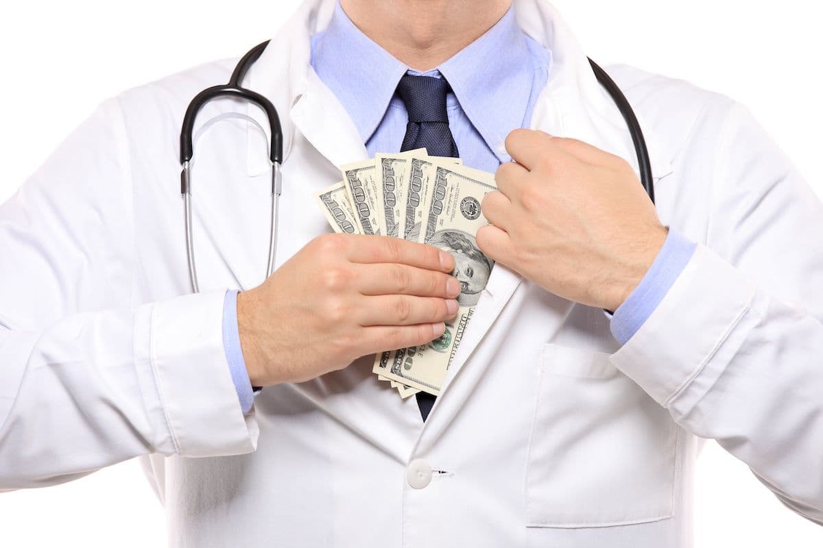 physician doctor putting money in pocket © Ljupco Smokovski - stock.adobe.com